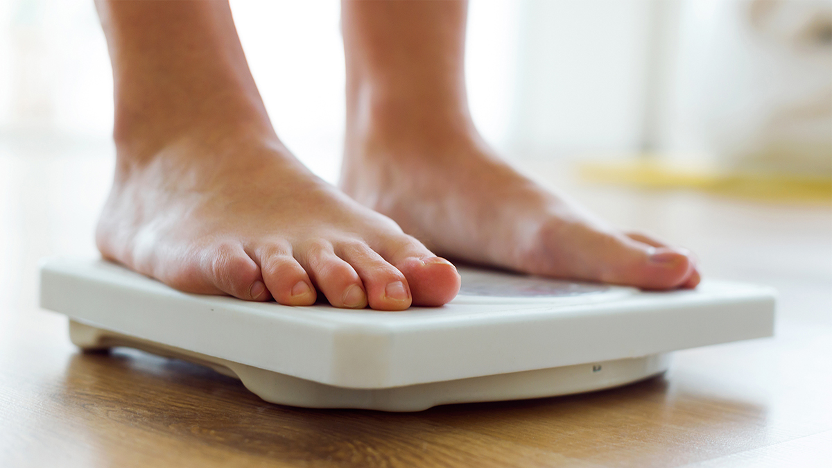 Young healthy girl on home scales.